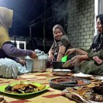 Emak-emak menyiapkan makanan dan lauk pauk di acara malam tahun baru 2026.