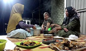 Emak-emak menyiapkan makanan dan lauk pauk di acara malam tahun baru 2026.